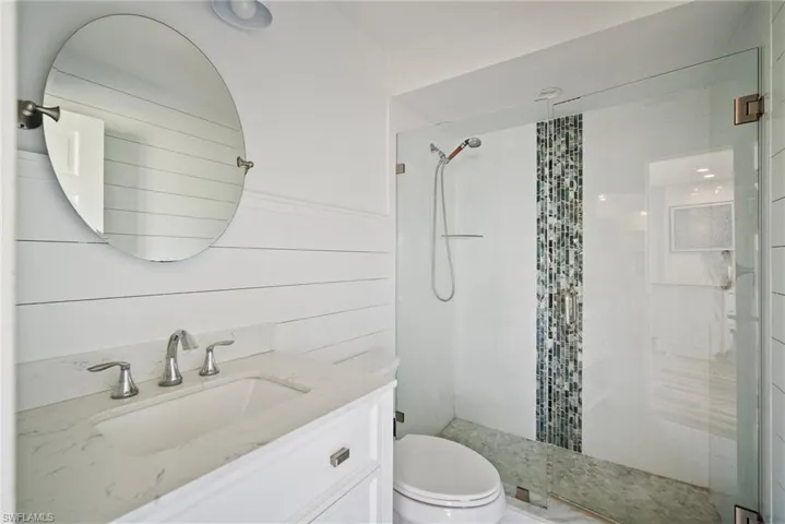 Bathroom featuring vanity, an enclosed shower, and toilet