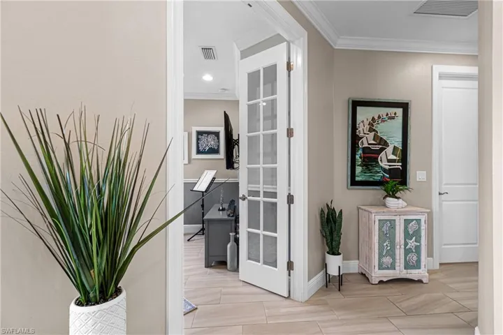 Hall featuring ornamental molding and french doors