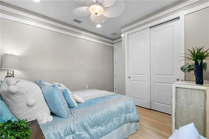 Bedroom featuring light hardwood / wood-style floors, ceiling fan, and a closet