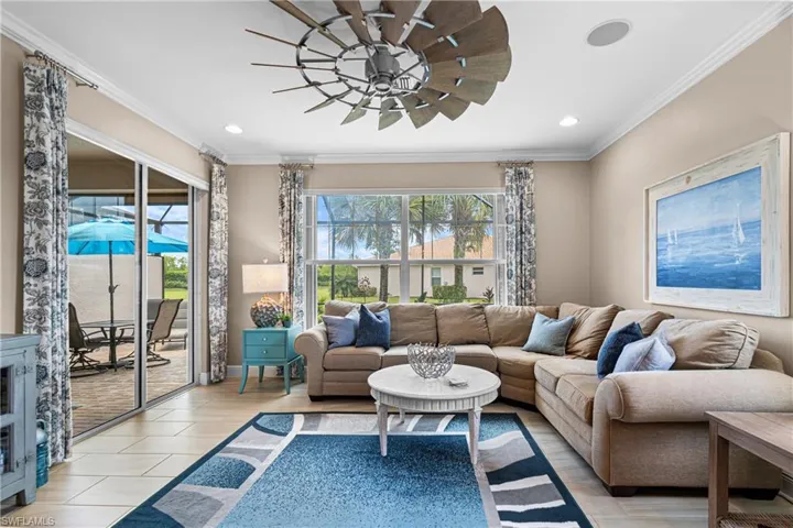 Tiled living room with crown molding and ceiling fan