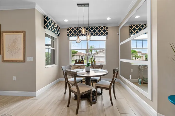 Dining space with an inviting chandelier, light wood-type flooring, plenty of natural light, and crown molding