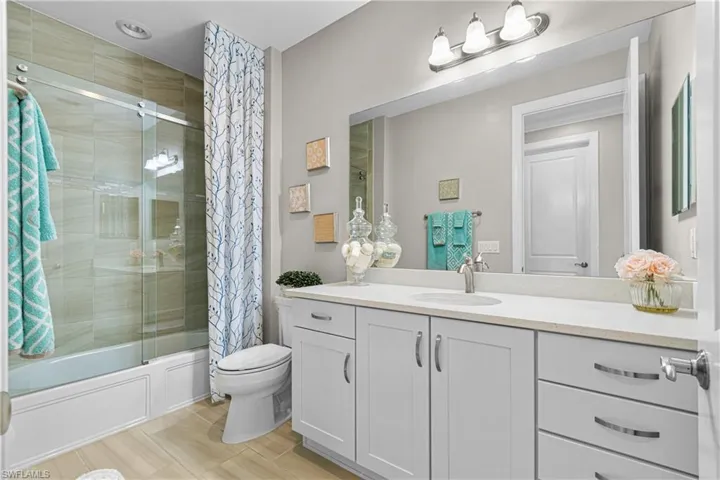 Full bathroom with vanity, hardwood / wood-style floors, toilet, and shower / bath combo