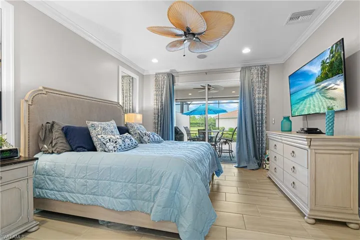 Bedroom with light hardwood / wood-style floors, ceiling fan, access to outside, and crown molding