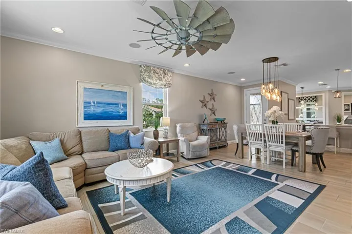 Living room featuring a notable chandelier, crown molding, and hardwood / wood-style flooring