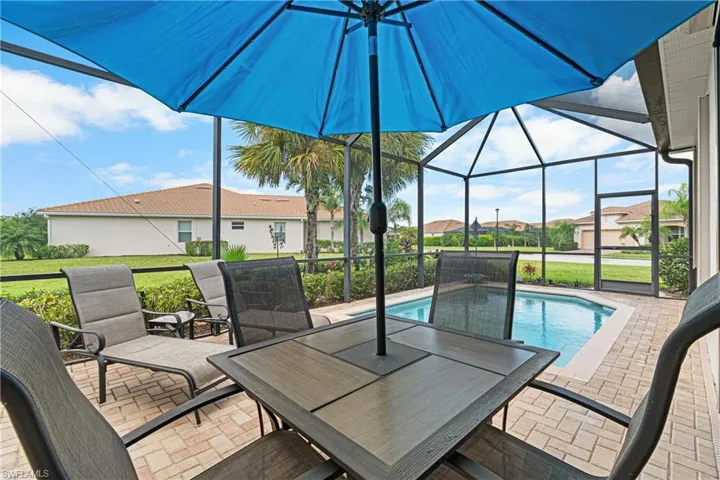 View of swimming pool with glass enclosure and a patio area