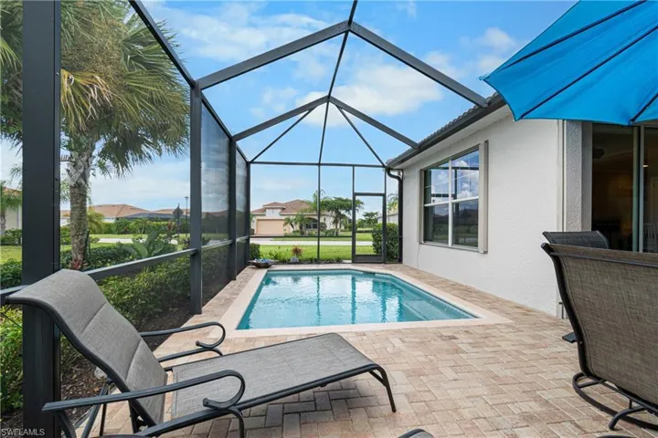 View of pool with a patio and glass enclosure
