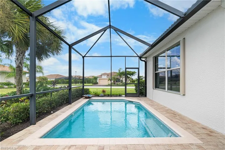 View of swimming pool featuring glass enclosure