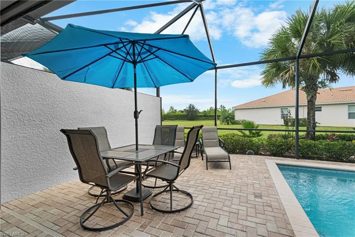 View of swimming pool with glass enclosure and a patio area