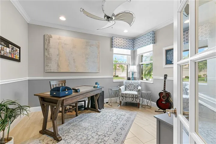 Office space with ceiling fan, light tile patterned flooring, and crown molding