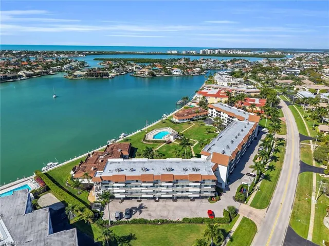 Bird's eye view of a pool area and a nearby body of water