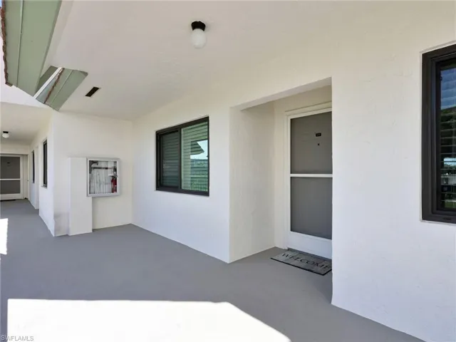 Doorway to property featuring stucco siding and a patio area