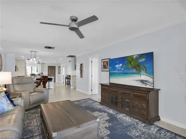 Living room with crown molding and ceiling fan