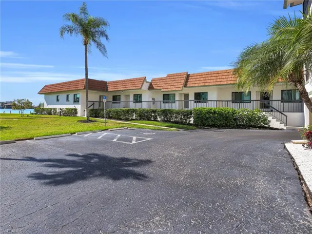 View of building exterior with uncovered parking