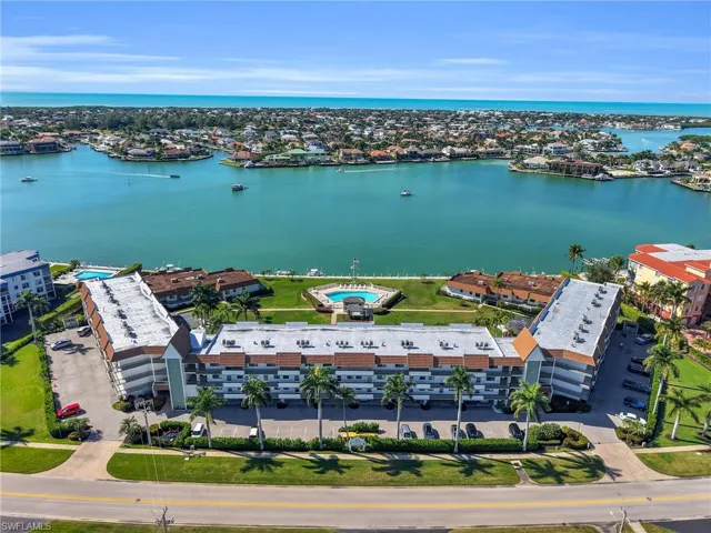 Drone / aerial view of apartment complex / building and a nearby body of water