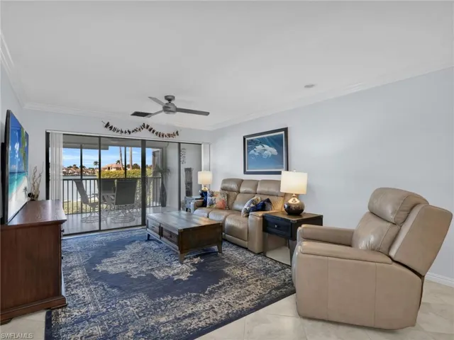 Living area featuring ornamental molding, ceiling fan, and light tile patterned floors