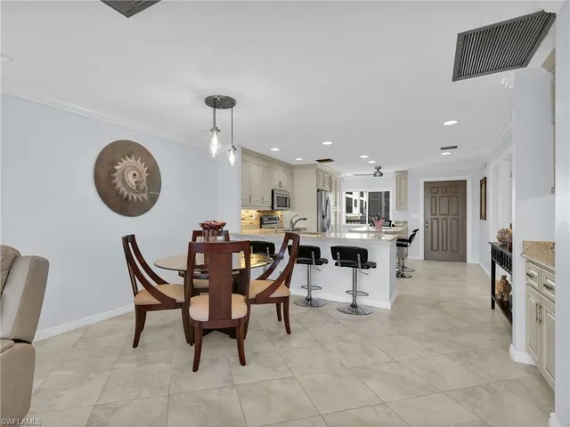 Dining space with crown molding, recessed lighting, and light tile patterned flooring