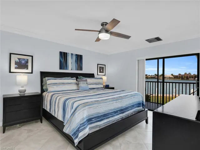 Bedroom with crown molding, access to exterior, a water view, and ceiling fan