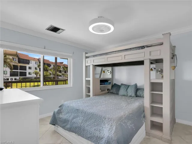 Bedroom with ornamental molding and light tile patterned floors