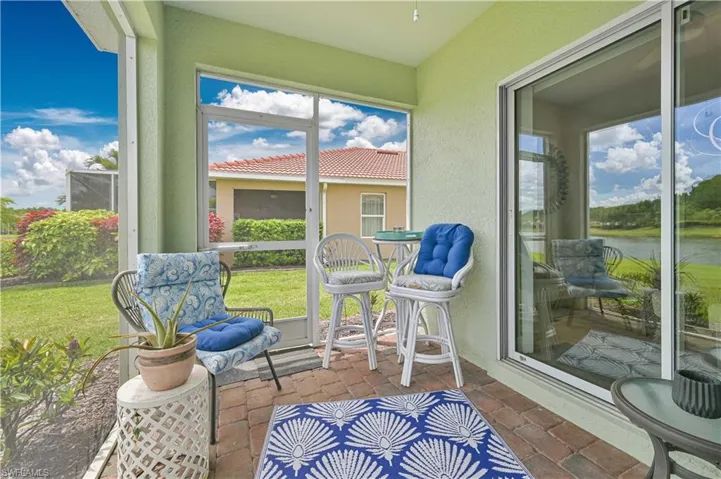 Screened patio featuring brick pavers and a serene water backdrop