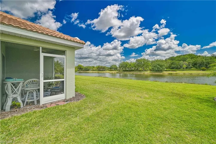 Screened patio with tile roof, overlooking expansive lawn and waterfront