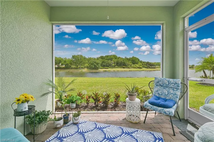 Screened patio featuring brick paver flooring, textured exterior walls, and a landscaped border