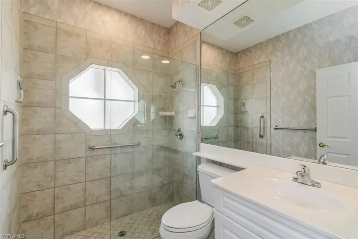 Bathroom with an enclosed shower, vanity, and toilet