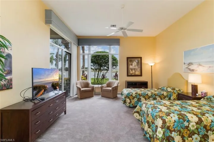 Carpeted bedroom with ceiling fan and access to outside