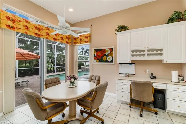 Tiled dining area with ceiling fan and built in desk