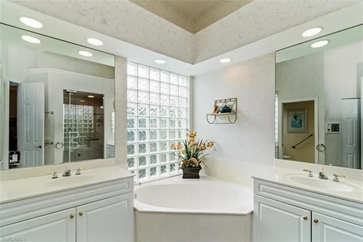 Bathroom featuring a bath, dual sinks, and oversized vanity