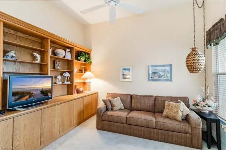 Den featuring ceiling fan and light colored carpet