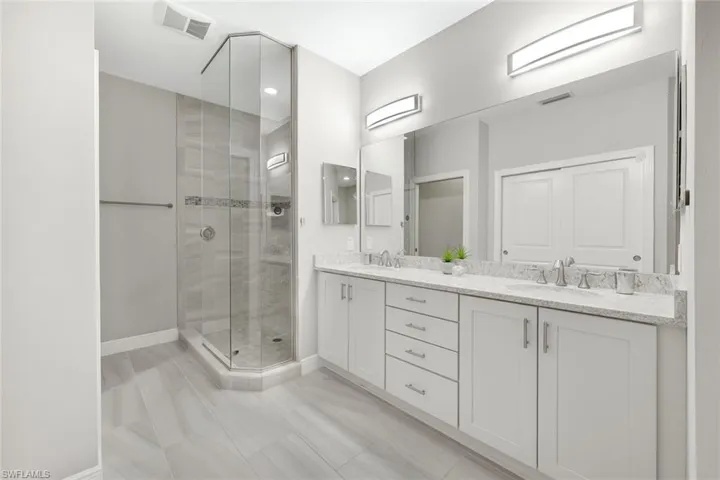 Dual sinks, ample cabinet space, upscale lighting and a beautifully tiled walk in shower.