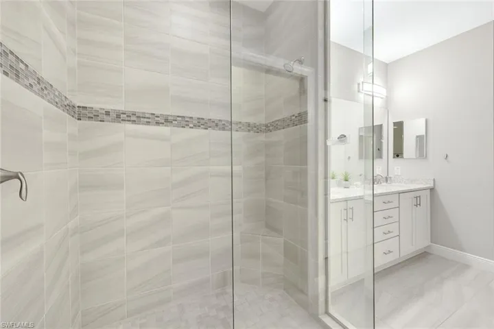 Luxurious frameless walk-in shower with full tile surround.