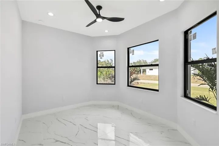 Unfurnished room featuring marble finish floors, ceiling fan, and recessed lighting