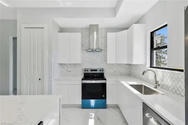 Kitchen with modern cabinets, stainless steel appliances, and light stone counters