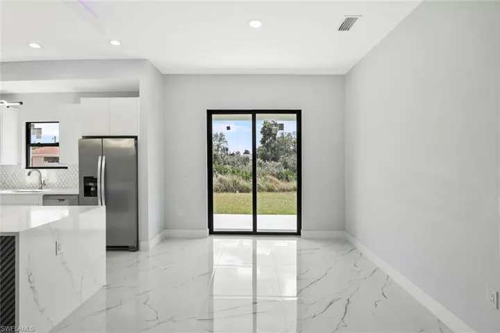 Unfurnished dining area with light marble finish flooring and recessed lighting