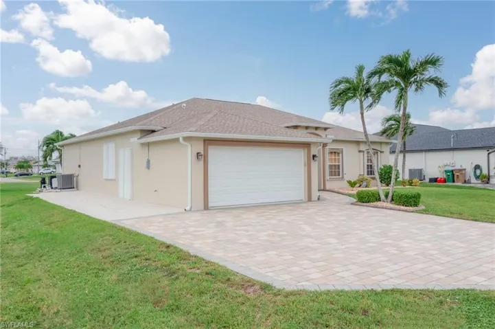Ranch-style home with a garage, central AC, and a front lawn