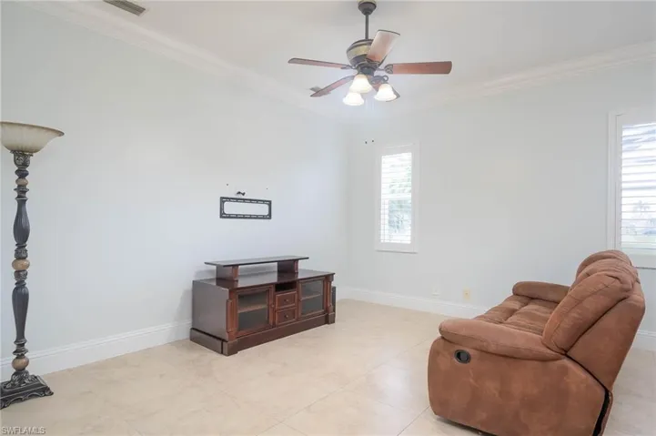 Sitting room featuring ceiling fan and ornamental molding