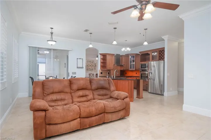 Living room with sink, ceiling fan, and crown molding