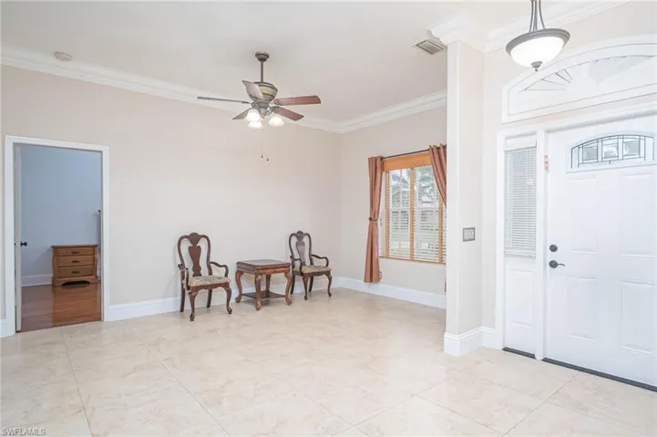 Entrance foyer featuring ceiling fan and ornamental molding