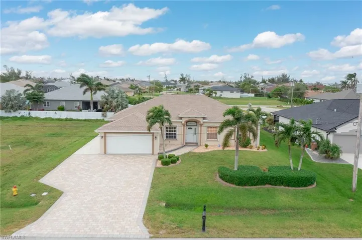 View of front of property featuring a front lawn and a garage