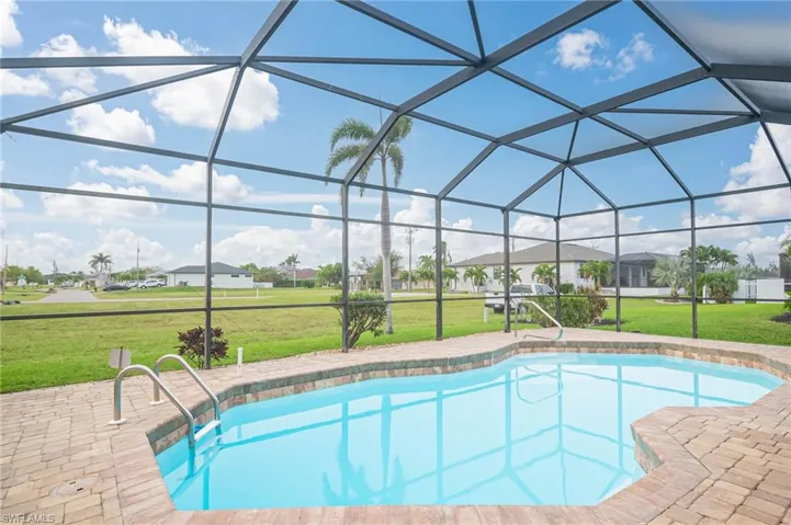 View of swimming pool featuring a patio, a yard, and a lanai