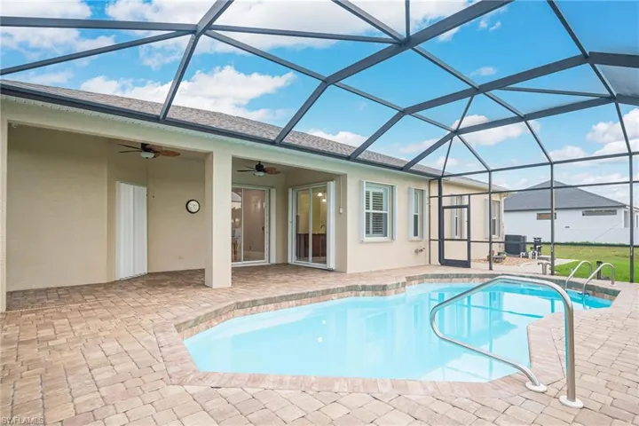 View of swimming pool featuring glass enclosure, central air condition unit, a patio, and ceiling fan