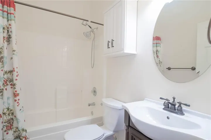 Full bathroom featuring vanity, shower / bath combo with shower curtain, and toilet