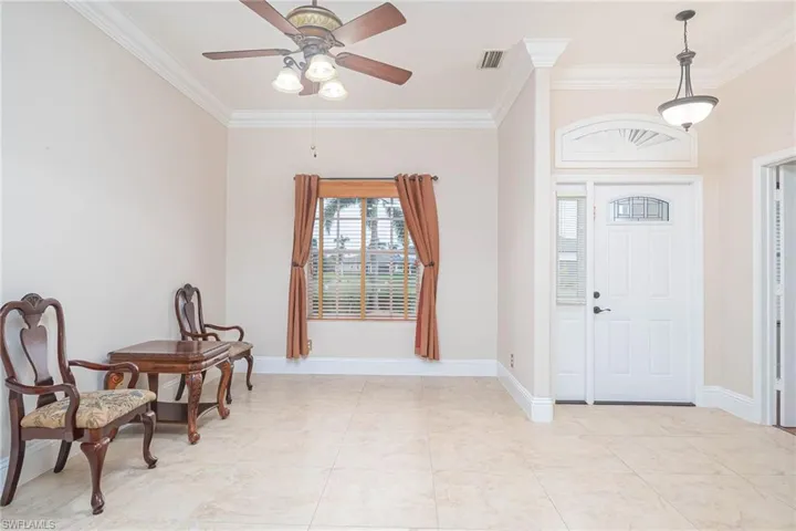 Entryway with ceiling fan and crown molding