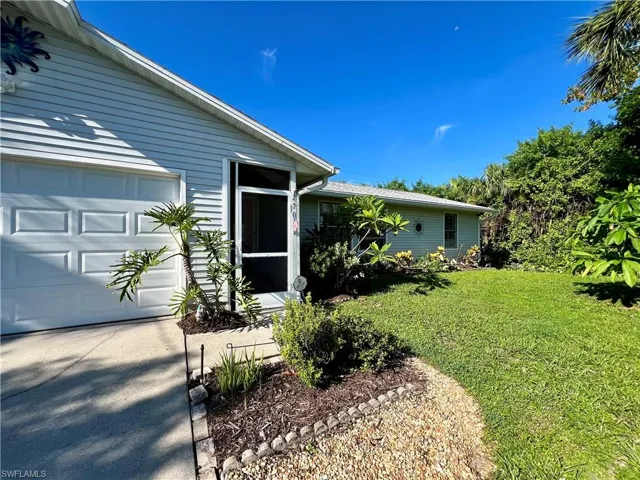 View of front of house with a garage and a front yard