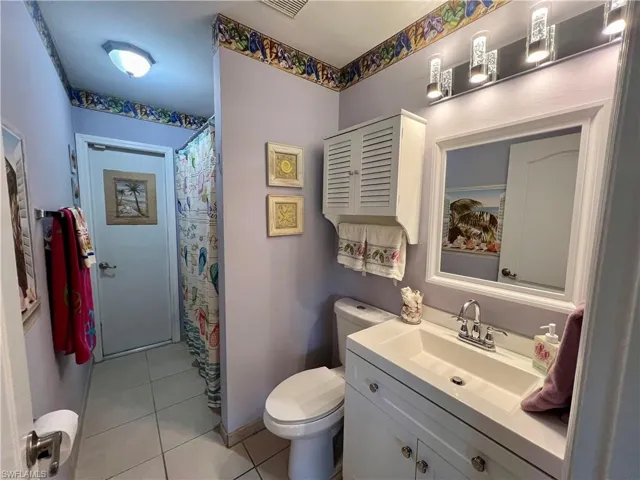 Bathroom featuring tile flooring, vanity, and toilet
