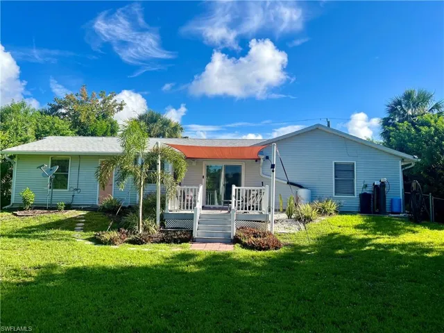 Back of house with a yard