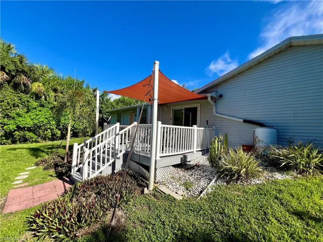 View of home's exterior featuring a deck and a yard