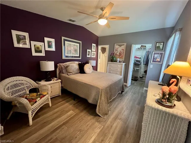 Master Bedroom featuring a walk in closet, ceiling fan, vaulted ceiling, and luxury vinyl plank flooring