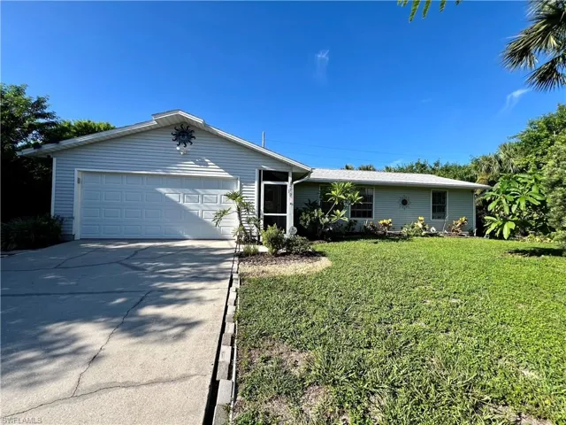 Ranch-style home with a front lawn and a garage